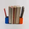 A book-shaped bookend that doubles as a storage organizer for bookmarks, pens, and small desk accessories, perfect for book lovers and office decor.