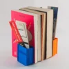 A book-shaped bookend that doubles as a storage organizer for bookmarks, pens, and small desk accessories, perfect for book lovers and office decor.