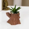 An old tree stump planter with a wood-like design, perfect for air plants, garden decoration, and makeup brushes. A stylish and functional addition to your home or garden decor.