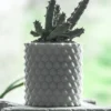 A pineapple-patterned cylinder planter, perfect for holding plants, pens, brushes, and more. A stylish and functional addition to your home or office decor.