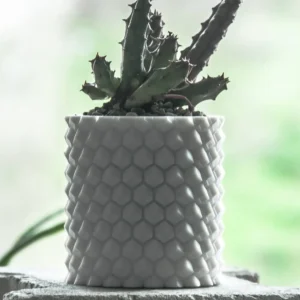 A pineapple-patterned cylinder planter, perfect for holding plants, pens, brushes, and more. A stylish and functional addition to your home or office decor.