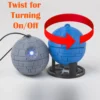 A Star Wars Death Star ornament with a twist mechanism that activates an LED light. Perfect for adding a galactic touch to your Christmas tree.