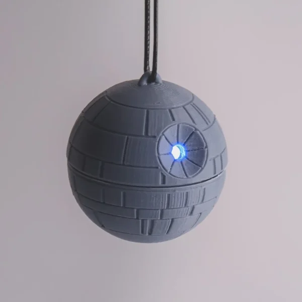 A Star Wars Death Star ornament with a twist mechanism that activates an LED light. Perfect for adding a galactic touch to your Christmas tree.