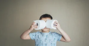 kid holds toilet paper